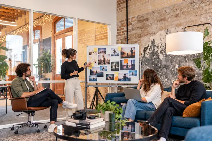 Ein kreatives Marketingteam bespricht eine Kampagne in einem hellen kollaborativen Arbeitsbereich.